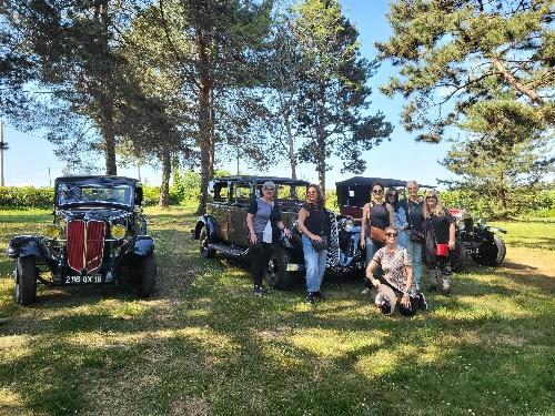 People posing with historical cars in France